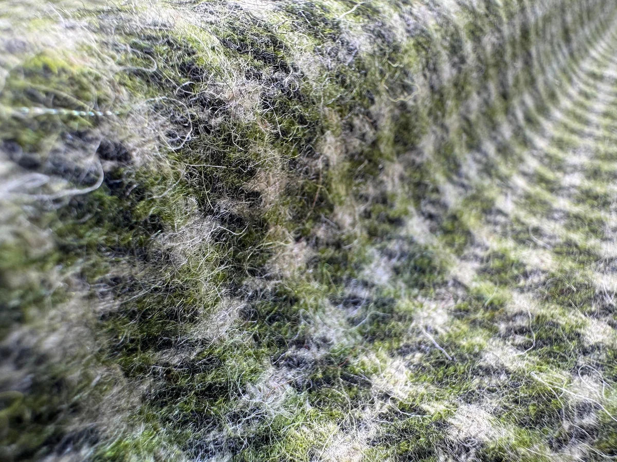 Close-up of a marino tweed with green and black patterns